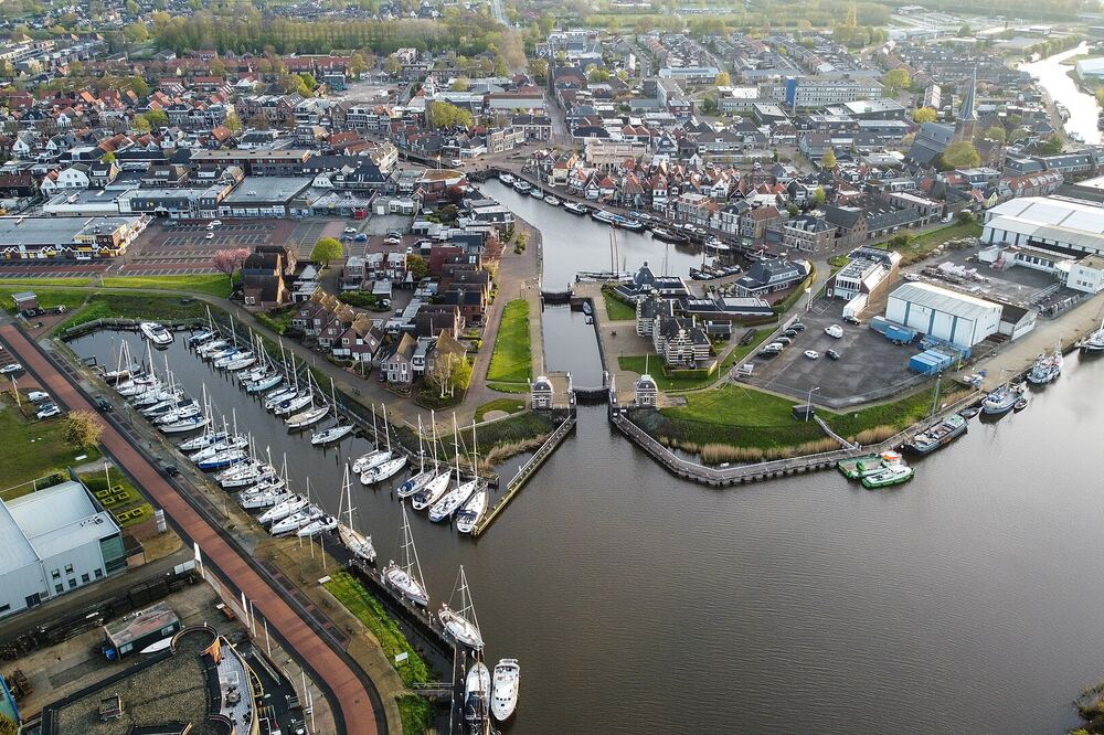 Luchtfoto van Lemmer met de oude sluis, de jachthaven met zeilboten en het dorp erachter