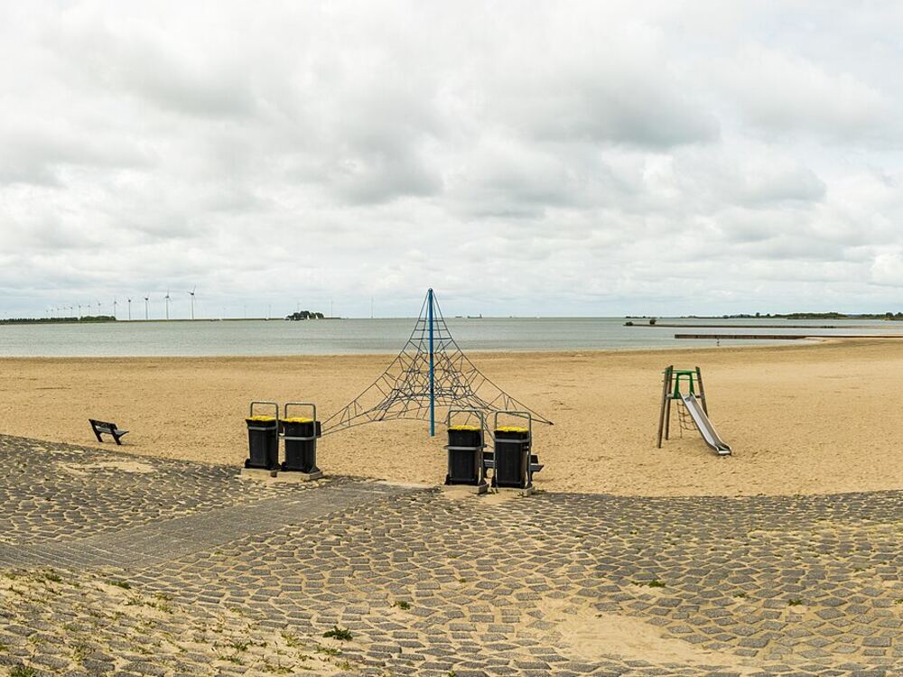Zandstrand van Lemmer aan het IJsselmeer met klimnet, glijbaan en schommel voor kinderen